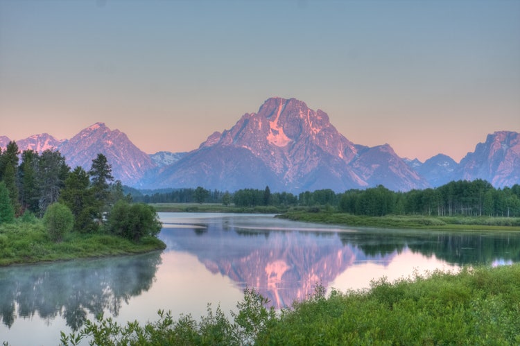 Grand Tetons from Oxbow Lake overlook at sunrise on 7/23/09 (in HDR). Notice the moose swimming across the lake near the top of the lake).